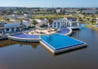 Vista aérea da piscina e área de lazer sobre o lago — Condomínio Enseada Lagos