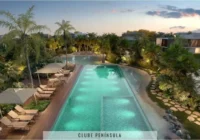 Vista aérea da piscina iluminada com área de lazer e paisagismo — Condomínio Raro