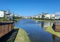 Vista do lago artificial cercado por casas e decks de madeira — Condomínio Rossi Atlântida