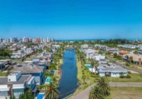 Vista aérea do condomínio com canal artificial e casas de alto padrão — Condomínio Villaggio Atlântida