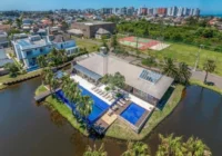 Vista aérea da infraestrutura de lazer do condomínio com piscinas e lago — Condomínio Villaggio Atlântida