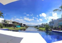 Piscina com borda infinita e vista para o canal do condomínio — Malibu Beach Residence