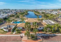 Vista aérea de casa de alto padrão em condomínio com lago — Quintas do Lago