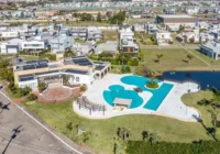 Vista aérea da área de lazer do condomínio com piscina e lago — Sea Coast Beach Village